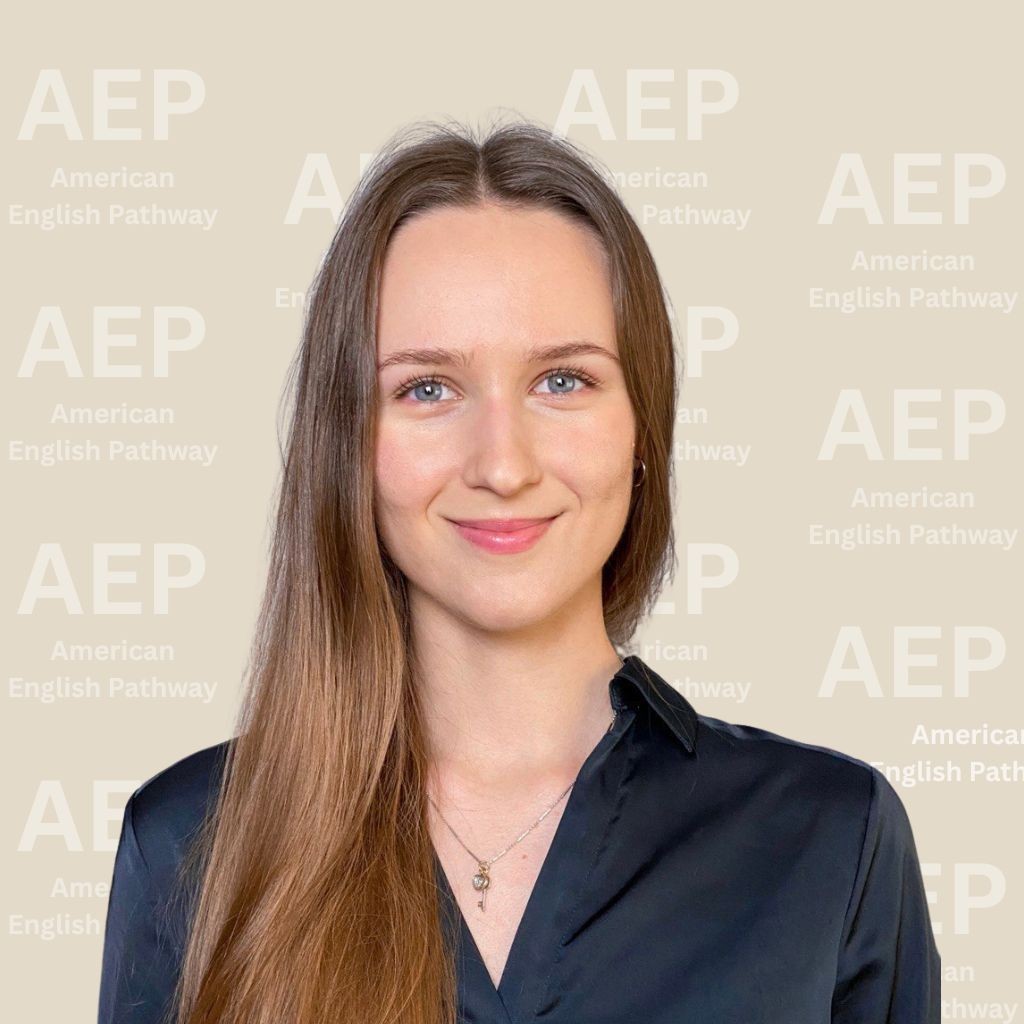 Woman in a black shirt smiling with AEP American English Pathway background.